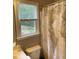 Bathroom with window view, toilet, vanity, and world map shower curtain at 107 Sedgefield Overlook, Dallas, GA 30157