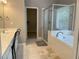 Bathroom featuring a soaking tub, shower with glass door, and double sink vanity at 107 Sedgefield Overlook, Dallas, GA 30157