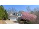 Two-story home boasts a well-manicured lawn, a tree with pink blooms, and a classic American flag at 107 Sedgefield Overlook, Dallas, GA 30157
