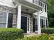 Home entrance with stone facade, black shutters, manicured hedges, and charming front door at 107 Sedgefield Overlook, Dallas, GA 30157