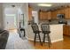 Kitchen and entry featuring wooden cabinets, granite countertops, and black bar stools at 107 Sedgefield Overlook, Dallas, GA 30157