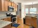 Kitchen boasts granite countertops, stainless steel appliances, and warm wood cabinetry at 107 Sedgefield Overlook, Dallas, GA 30157