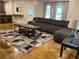 Open living room with dark brown reclining sofa, a rug with many colors, and large windows at 107 Sedgefield Overlook, Dallas, GA 30157