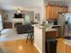 View of kitchen and adjacent living room with fireplace and flat screen TV at 107 Sedgefield Overlook, Dallas, GA 30157