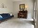 Cozy living room featuring a comfortable sofa, antique desk, and soft carpeting at 107 Sedgefield Overlook, Dallas, GA 30157