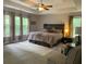 Primary bedroom with tray ceiling, a large window, seating area, and king bed at 107 Sedgefield Overlook, Dallas, GA 30157
