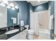 Well-maintained bathroom features dark blue walls, a shower-tub combo, and granite countertops at 1717 N Decatur Ne Rd # 322, Atlanta, GA 30307