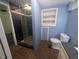Bathroom features a black marbled glass shower, blue walls, gray countertops, and brown tile flooring at 5882 Grandview Nw Ct, Acworth, GA 30101