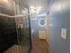 Bathroom boasts a black marbled glass shower, blue walls, brown tile flooring, and white vanity at 5882 Grandview Nw Ct, Acworth, GA 30101