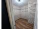 Walk-in closet with wood floors and built-in shelving at 5882 Grandview Nw Ct, Acworth, GA 30101