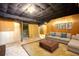 Staged basement with paneled walls, drop ceiling and tan colored sofa at 749 Dogwood Dr, Lawrenceville, GA 30046