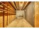 Unfinished basement with open ceiling, concrete floor, block wall, and built-in shelving for easy storage at 749 Dogwood Dr, Lawrenceville, GA 30046