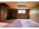 Unfinished basement area with bare floors, paneled walls and small window at 749 Dogwood Dr, Lawrenceville, GA 30046
