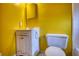 View of a worn bathroom with a yellow wall, toilet, sink and mirror at 749 Dogwood Dr, Lawrenceville, GA 30046