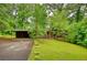 Charming exterior showcasing a well-maintained lawn, carport, and a lush, green surrounding landscape at 749 Dogwood Dr, Lawrenceville, GA 30046