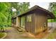 Back of home showcasing outdoor patio, vertically paneled siding, and beautiful lush trees at 749 Dogwood Dr, Lawrenceville, GA 30046