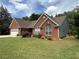 This brick home boasts manicured landscaping, a two-car garage, and lovely curb appeal at 1245 Mulberry Mill Ln, Lawrenceville, GA 30043
