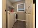 Convenient laundry room featuring a washer, dryer, storage shelf, and window for natural light at 1245 Mulberry Mill Ln, Lawrenceville, GA 30043