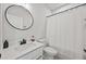 Modern bathroom with a white vanity, round mirror, and shower with white tiling at 125 Climbing Ivy Cir, Fayetteville, GA 30214