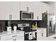 Modern kitchen featuring stainless steel appliances, black backsplash, and white cabinetry at 125 Climbing Ivy Cir, Fayetteville, GA 30214