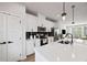 Bright, white kitchen features stainless steel appliances and an island with quartz countertops at 125 Climbing Ivy Cir, Fayetteville, GA 30214