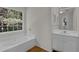 Bright bathroom featuring tub and window with forest view at 1387 Sw Haynes Meadow Trl, Grayson, GA 30017