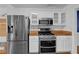 Well-equipped kitchen featuring stainless steel appliances, white cabinets, and butcher block countertops at 1387 Sw Haynes Meadow Trl, Grayson, GA 30017
