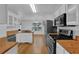 Well-lit kitchen featuring stainless steel appliances, white cabinets, and butcher block countertops at 1387 Sw Haynes Meadow Trl, Grayson, GA 30017