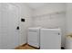 Functional laundry room with modern appliances, shelving for storage, and a door at 1387 Sw Haynes Meadow Trl, Grayson, GA 30017