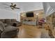 Spacious living room with hardwood floors, wood-paneled accent wall, and a comfortable sectional sofa at 1387 Sw Haynes Meadow Trl, Grayson, GA 30017