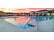 Outdoor pool with splashpad features with sunset sky and community buildings at 301 Sandy Oak Dr, Loganville, GA 30052