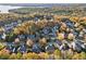 A beautiful aerial view of a neighborhood with mature trees and a lake in the background during the Fall at 424 Lake Point Trce, Canton, GA 30114