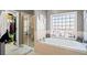 Bright bathroom featuring a soaking tub next to a large window and a glass-enclosed shower at 424 Lake Point Trce, Canton, GA 30114