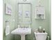 Charming powder room with a pedestal sink and a decorative mirror, enhanced by soft green walls at 424 Lake Point Trce, Canton, GA 30114