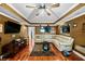 Spacious living room with dark wooden floors, tan sofa, tray ceiling, and ceiling fan at 424 Lake Point Trce, Canton, GA 30114