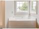 A bathtub with jets sits beneath a window in this bathroom at 7006 Mahonia Place, Stonecrest, GA 30038