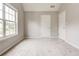 A bright bedroom features a large window, neutral walls, and plush carpeting at 7006 Mahonia Place, Stonecrest, GA 30038