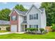 Charming two-story home features a well-manicured lawn, a brick facade, and complementary neutral siding at 7006 Mahonia Place, Stonecrest, GA 30038