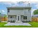 Rear exterior view of a two-story home, with a well-manicured yard and patio at 7006 Mahonia Place, Stonecrest, GA 30038