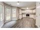 Bright kitchen boasts white cabinets, stainless steel appliances, and wood-look floors at 7006 Mahonia Place, Stonecrest, GA 30038
