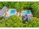 Aerial view of community pools, with lounge chairs and umbrellas amidst green landscaping at 9691 Squirrel Wood Run, Douglasville, GA 30135