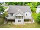 Aerial view of home with back deck, screened-in porch, mature trees, and well-manicured lawn at 9691 Squirrel Wood Run, Douglasville, GA 30135