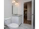 Bright bathroom showcasing a granite-topped vanity, toilet, and doorway leading to another room with hardwood flooring at 9691 Squirrel Wood Run, Douglasville, GA 30135