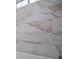 Close-up of a marble-patterned tile wall in a bathroom, above a tub, showcasing a modern design at 9691 Squirrel Wood Run, Douglasville, GA 30135