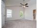 Spacious bedroom with neutral carpet, ceiling fan, and a glimpse into the ensuite bathroom at 9691 Squirrel Wood Run, Douglasville, GA 30135