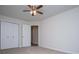 Cozy bedroom features neutral carpet, a ceiling fan, and double doors leading to closet at 9691 Squirrel Wood Run, Douglasville, GA 30135