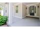 Inviting front entrance featuring a covered porch, sidelights, black front door, and decorative lighting at 9691 Squirrel Wood Run, Douglasville, GA 30135