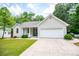 Charming single-story home featuring a painted brick facade, attached two-car garage, and manicured front lawn at 9691 Squirrel Wood Run, Douglasville, GA 30135