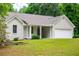 Well-maintained lawn surrounding a charming brick home with a covered front porch at 9691 Squirrel Wood Run, Douglasville, GA 30135