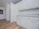 Kitchen featuring white cabinets, granite countertops, and stylish wood-look flooring at 9691 Squirrel Wood Run, Douglasville, GA 30135